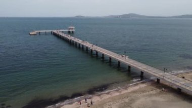 Burgaz Köprüsü 'nün havadan görüntüsü. Rıhtımda yürüyen insanlar. Bulgaristan 'ın Burgaz Koyu' nun güzel deniz manzarası.