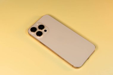 BURGAS, BULGARIA - 30 Kasım 2025: Sarı zemin üzerinde Apple iPhone 16 Pro Max Desert Titanium.