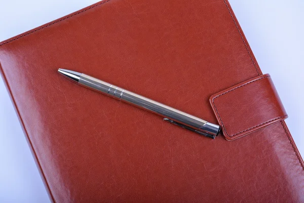 Ball pen on red leather diary — Stock Photo, Image