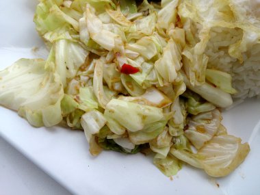 Fry lahana, balık sosu ve kızarmış domuz eti ile tavada kızartılmış lahana beyaz tabak içinde karıştırın.