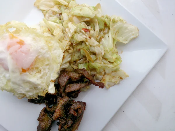 Mexer repolho frito, repolho frito com molho de peixe e carne de porco frita no prato branco . — Fotografia de Stock