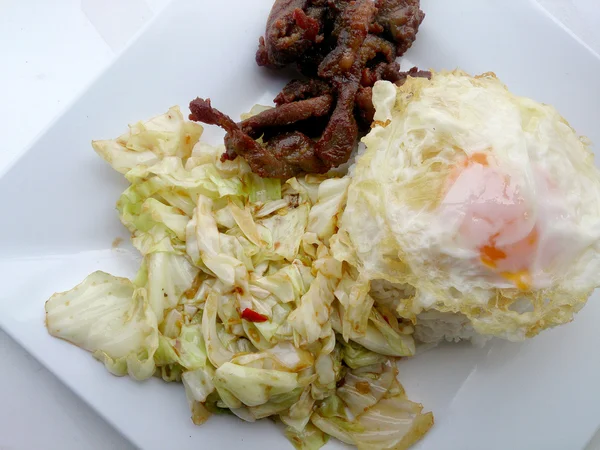 Fry lahana, balık sosu ve kızarmış domuz eti ile tavada kızartılmış lahana beyaz tabak içinde karıştırın. — Stok fotoğraf