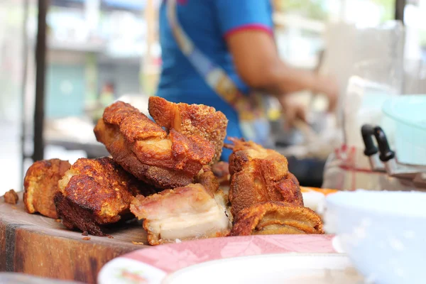 Panceta de cerdo asado oriental en tabla de cortar de madera con mujeres del mercado — Foto de Stock