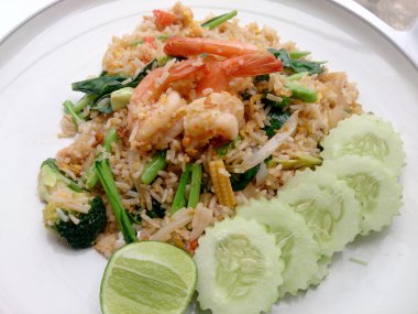 Beyaz tabakta karidesli kızarmış pirinç.