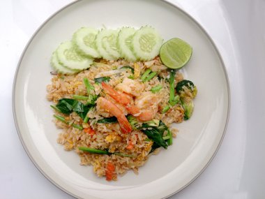 Beyaz tabakta karidesli kızarmış pirinç.