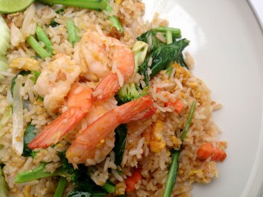 Beyaz tabakta karidesli kızarmış pirinç.