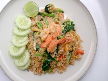 Beyaz tabakta karidesli kızarmış pirinç.