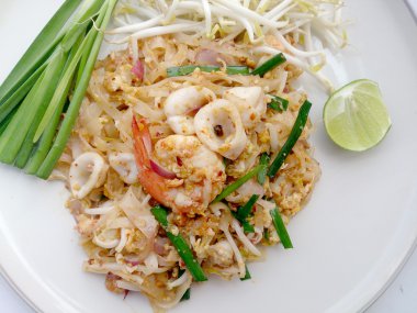 Tay tarzında erişte. Tayland'ın Millî yemekleri, karides ve kalamar (Pad Tay ile tavada kızartılmış Pirinç Noodle)
