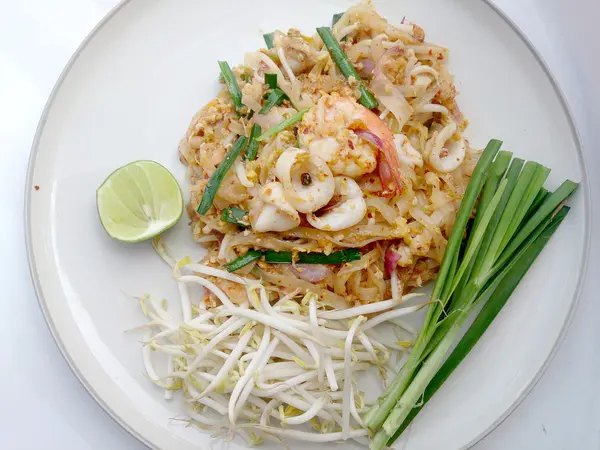 Лапша в тайском стиле. Национальные блюда Таиланда, жареная рисовая лапша с креветками и кальмарами (Pad Thai ) — стоковое фото