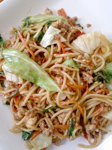 Ahşap masa üzerinde beyaz tabak acılı spagetti