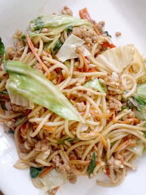 Ahşap masa üzerinde beyaz tabak acılı spagetti