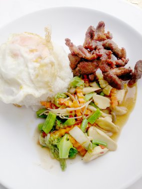 İstiridye sosu ve kızarmış dilimlenmiş domuz eti ve sahanda yumurta pirinç ikramederse karışık sebze.