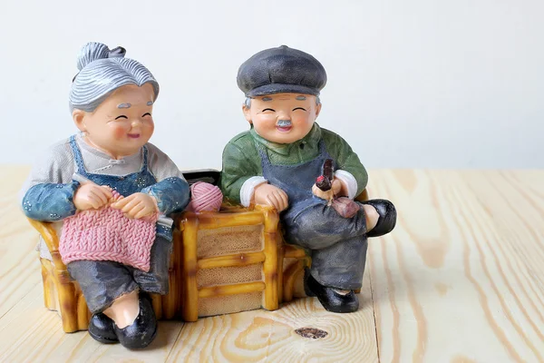 Schöne Großelternpuppe Sitten Schaukelstuhl aus Holz auf Holz Hintergrund — Stockfoto