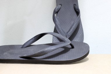 vintage tarzı ve düşük ışık ahşap üzerine siyah parmak arası terlik.