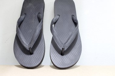 vintage tarzı ve düşük ışık ahşap üzerine siyah parmak arası terlik.