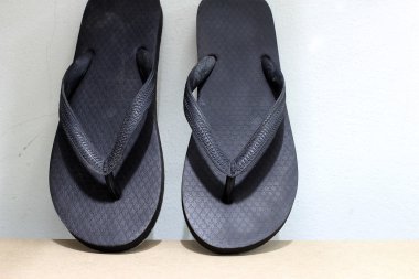 vintage tarzı ve düşük ışık ahşap üzerine siyah parmak arası terlik.