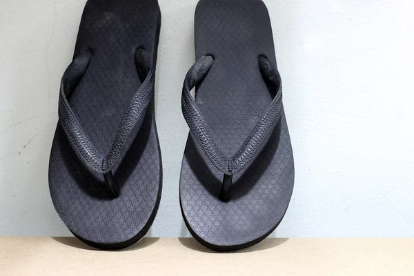 vintage tarzı ve düşük ışık ahşap üzerine siyah parmak arası terlik.