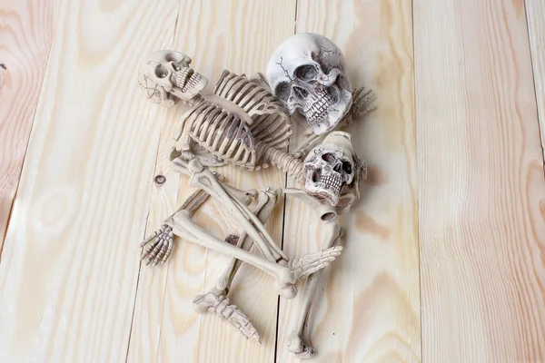 Lidská lebka a lidská kostra na borové dřevo pozadí — Stock fotografie