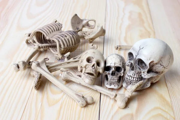 Crânio humano e esqueleto humano no fundo de madeira de pinho — Fotografia de Stock