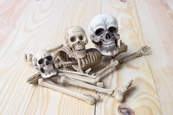 人类的头骨和人体骨架上松木材背景 — 图库照片