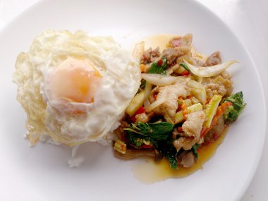 Fesleğen ekleyin sahanda yumurta ve pirinç tavada kızartılmış domuz ile tepesinde