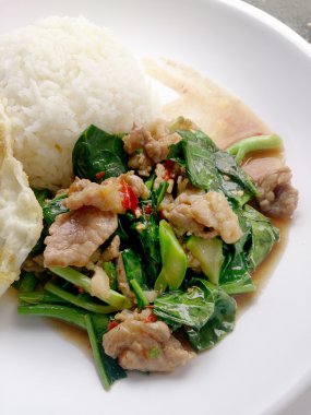 Kızarmış tavuk pilav ve kızarmış yumurta ile Kale Tayland lezzetli yemekleri ile. Tay tarzında.