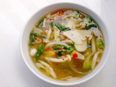 Sıcak ve baharatlı çorba, mantar, mix beyaz arka plan, vejetaryen yemek, sağlıklı gıda beyaz kase sebze ve Tay otlar