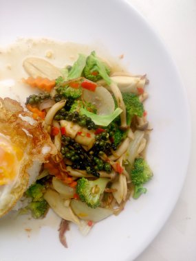 Tavada kızartılmış yemeğimi renkli sebze ve Tayland pirinç yasemin ve beyaz tabak kızarmış yumurta beyaz arka plan üzerinde izole et. Vejetaryen yiyecekler, sağlıklı gıda.