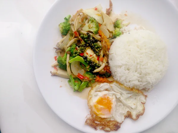 Lada hitam goreng dengan sayuran berwarna-warni dan nasi melati thai & telur goreng dalam hidangan isolasi putih di latar belakang putih. Makanan vegetarian, makanan sehat . — Stok Foto