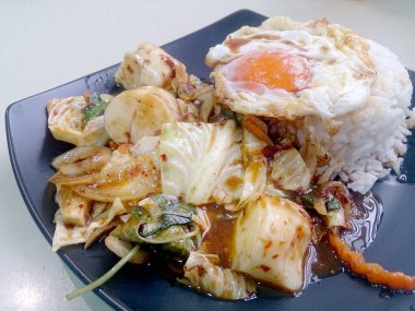Kavrulmuş Chili Yapıştır, kızarmış yumurta ve siyah çanak üzerinde Tayland Yasemin pirinç ile karışık sebze Fried karıştırın. Vejetaryen yiyecekler, sağlıklı gıda.