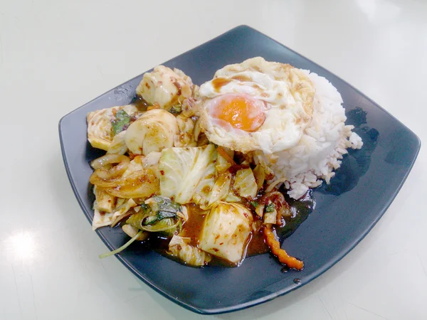 Ανακατεύετε τηγανισμένα ανάμικτα λαχανικά με πάστα τσίλι ψητό, τηγανητό αυγό & ταϊλανδέζικο ρύζι γιασεμιού στο μαύρο πιάτο. Χορτοφάγους τροφίμων, υγιεινή διατροφή. — Φωτογραφία Αρχείου