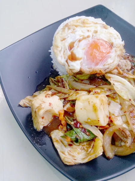 Revuelva las verduras fritas mezcladas con pasta de chile asado, huevo frito y arroz jazmín tailandés en el plato negro. Comida Vegetariana, comida saludable . —  Fotos de Stock