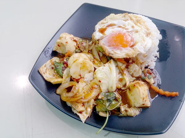 Mexer legumes fritos misturados com pasta de pimenta assada, ovo frito e arroz jasmim tailandês no prato preto. Comida vegetariana, comida saudável . — Fotografia de Stock