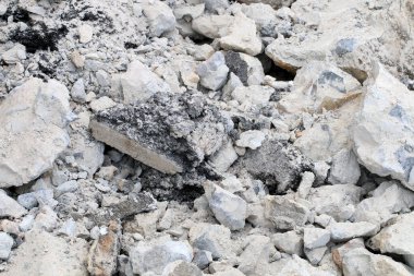 İnşaat alanında beton döşeme kırılmış. Çatlak beton doku arka planı. Çatlakları olan gri yüzey. Bir sürü parçalanmış alçı parçası. Ayrılma ve anlaşmazlık kavramı,