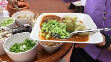 Yemek molası. Geleneksel Tayland kıyafetleri içinde eğitimliler ve öğrenciler yemek ya da Tayland usulü sebze yemeği için sırada bekliyorlar. Açık hava yemek partisi konsepti..