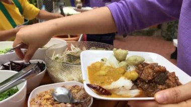 Yemek molası. Geleneksel Tayland kıyafetleri içinde eğitimliler ve öğrenciler yemek ya da Tayland usulü sebze yemeği için sırada bekliyorlar. Açık hava yemek partisi konsepti..