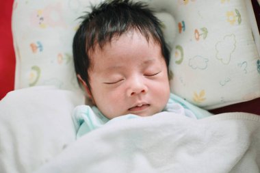 Bir bebeğin yakın çekimi. Yatakta uyumak, yeni doğmuş bebek.