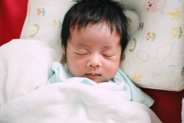 Bir bebeğin yakın çekimi. Yatakta uyumak, yeni doğmuş bebek.