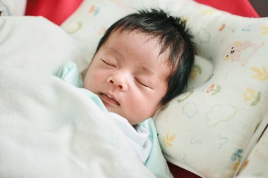 Bir bebeğin yakın çekimi. Yatakta uyumak, yeni doğmuş bebek.