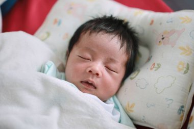 Bir bebeğin yakın çekimi. Yatakta uyumak, yeni doğmuş bebek.