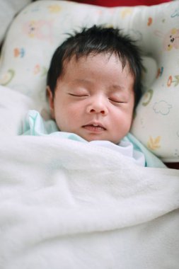 Bir bebeğin yakın çekimi. Yatakta uyumak, yeni doğmuş bebek.