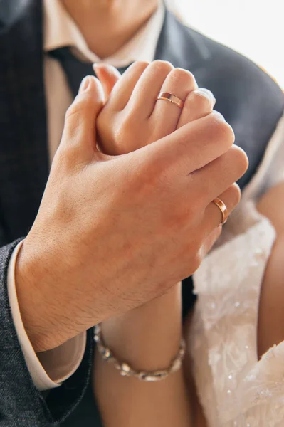 Yeni evli bir çiftin ellerini gösteren yakın çekim koleksiyonu. Resimlerde altın alyanslar, bir buket taze pembe gül ve el ele tutuşan çift yer alıyor. Aşk, evlilik, bağlılık ve mücevher kavramları.