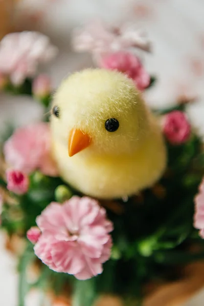 Yumurta kabuklu küçük bir yuvada iki sevimli oyuncak yavrunun yer aldığı neşeli Paskalya 'da hayat devam ediyor. Sahne benekli bıldırcın yumurtaları ve beyaz işlemeli masa örtüsü üzerinde taze pembe karanfil çiçekleriyle çevrilidir. Sıcak, aydınlık ve sıcak bir tatil.