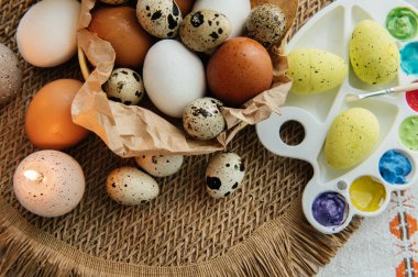 Yüksek açılı, kahverengi ve beyaz tavuk yumurtalarının yeniden kullanılabilir ağ iplik torbasına konulmuş karton bir kutuya konulmuş hali. Sahne, içinde iki tüylü sarı oyuncak civciv ve narin bahar çiçeklerinin bulunduğu küçük bir kuş yuvası ile süslenmiştir.,