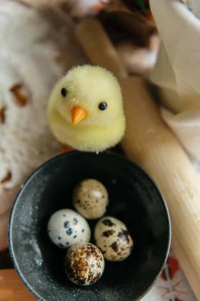 Yumurta kabuklu küçük bir yuvada iki sevimli oyuncak yavrunun yer aldığı neşeli Paskalya 'da hayat devam ediyor. Sahne benekli bıldırcın yumurtaları ve beyaz işlemeli masa örtüsü üzerinde taze pembe karanfil çiçekleriyle çevrili..