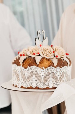 'Korovai' olarak bilinen güzel bir geleneksel Ukrayna düğün ekmeği, karmaşık hamur süsleri, dantel ve nakışlı kumaşla süslenmiştir. Set, tören sunumunu ve düğünü kesme geleneğini yakalıyor.