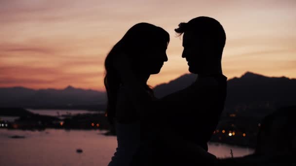 Пара целуется на закате прибрежного пейзажа — стоковое видео