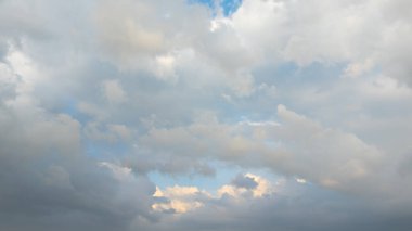 Parçalı bulutlu gökyüzü, beyaz ve gri bulutlarla mavi renkte karşıtlık ve atmosferik derinlik bölgelerine karşı..