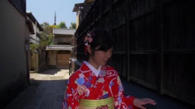 kimono giymiş güzel Japon kızı eski Kyoto çit ağır çekim yürür