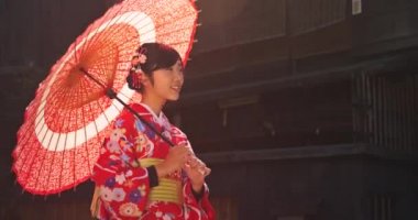 Tatlı Japon kadınların kimono döner kamera şemsiye ile giyiyor 